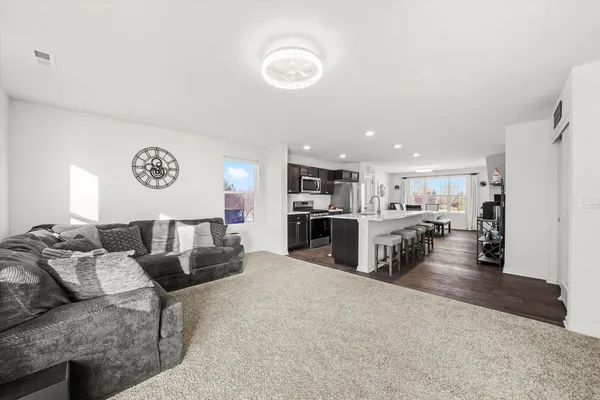 a living room with furniture and kitchen view
