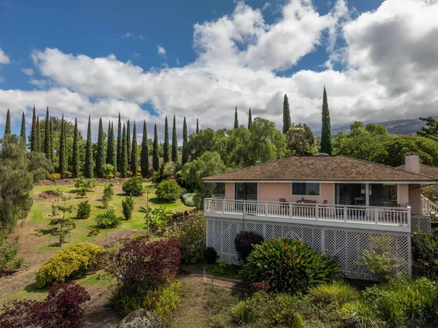 a view of a house with a big yard and flower plants