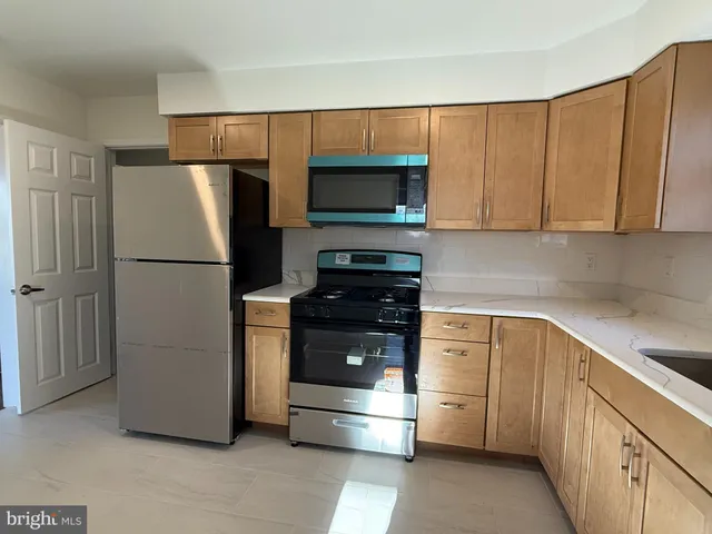 a kitchen with a refrigerator stove and cabinets