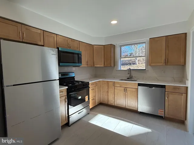 a kitchen with stainless steel appliances granite countertop a refrigerator sink and stove