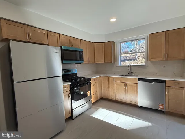 a white refrigerator freezer sitting inside of a kitchen with stainless steel appliances granite countertop cabinets and a refrigerator