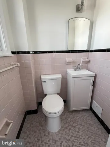 a bathroom with a toilet a sink and a mirror