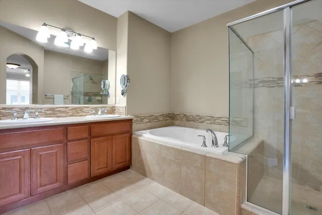 a spacious bathroom with a tub sink and mirror