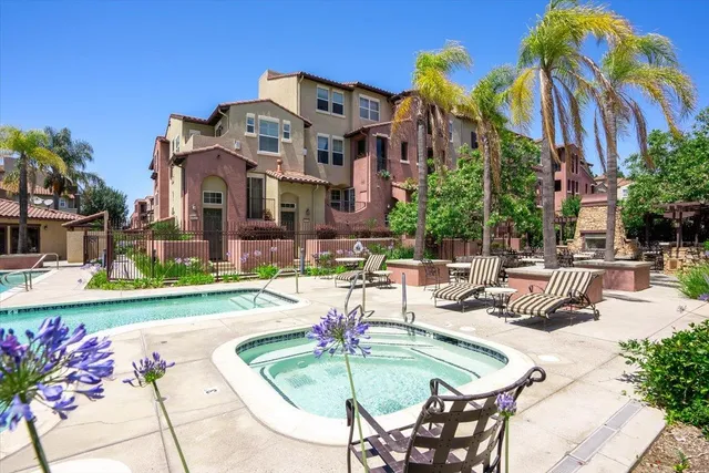 a view of a patio with couches table and chairs under an umbrella