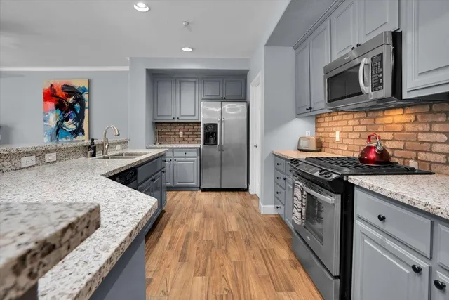 a kitchen with stainless steel appliances granite countertop a stove and a sink