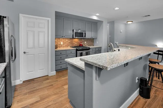 a kitchen with a sink refrigerator and cabinets