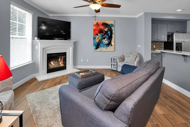 a living room with furniture a flat screen tv and a fireplace