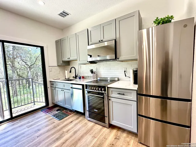 a kitchen with a refrigerator stove and wooden cabinets
