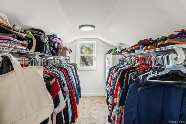 a view of walk in closet with clothes and shoes