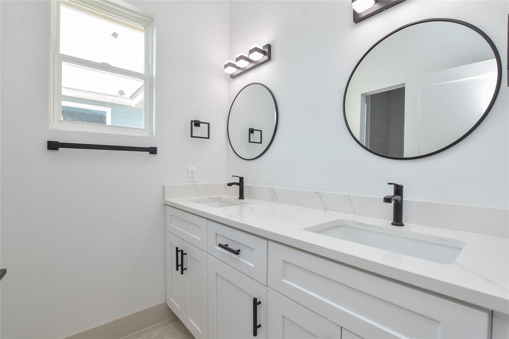 7103 Bennett Avenue, Unit 1 Austin, TX 78752 - Photo 19 of 25 a bathroom with a granite countertop double vanity sink and a mirror
