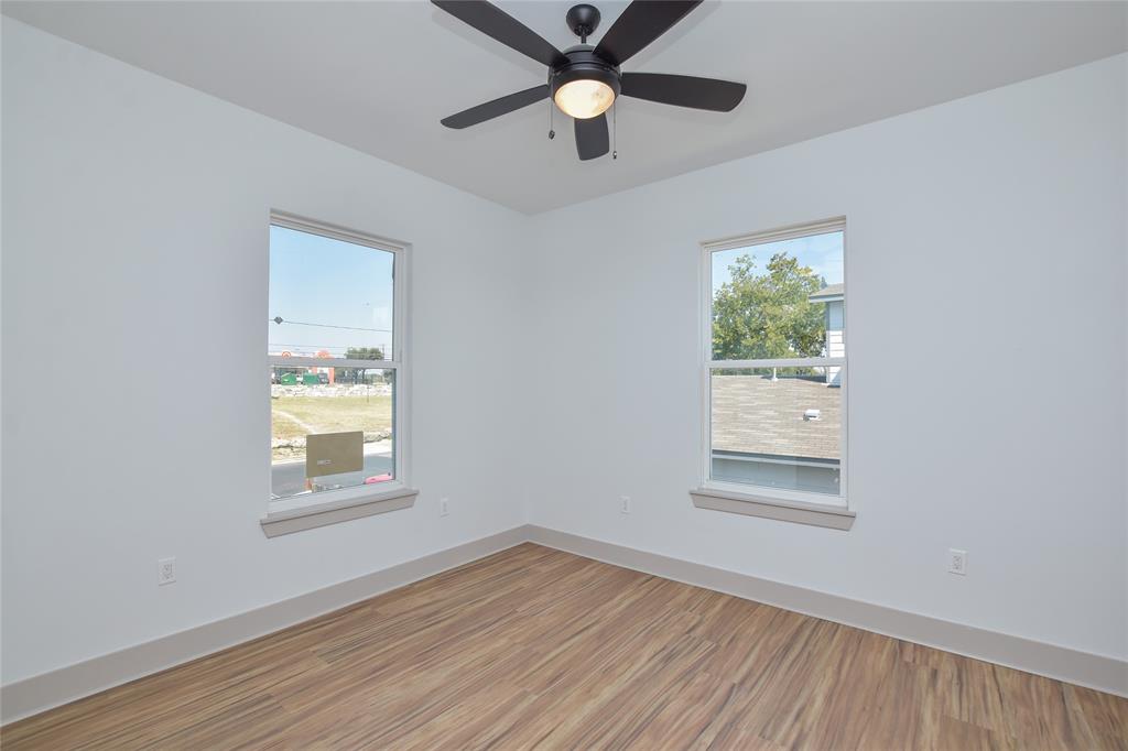 7103 Bennett Avenue, Unit 1 Austin, TX 78752 - Photo 21 of 25 an empty room with wooden floor a ceiling fan and windows