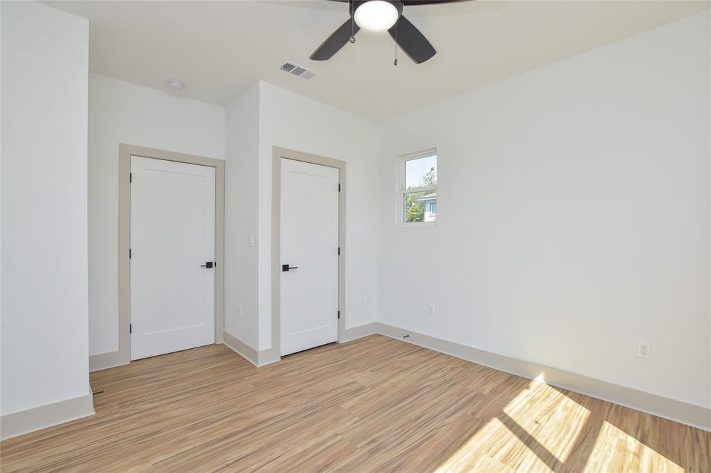 7103 Bennett Avenue, Unit 1 Austin, TX 78752 - Photo 22 of 25 an empty room with wooden floor chandelier fan and windows