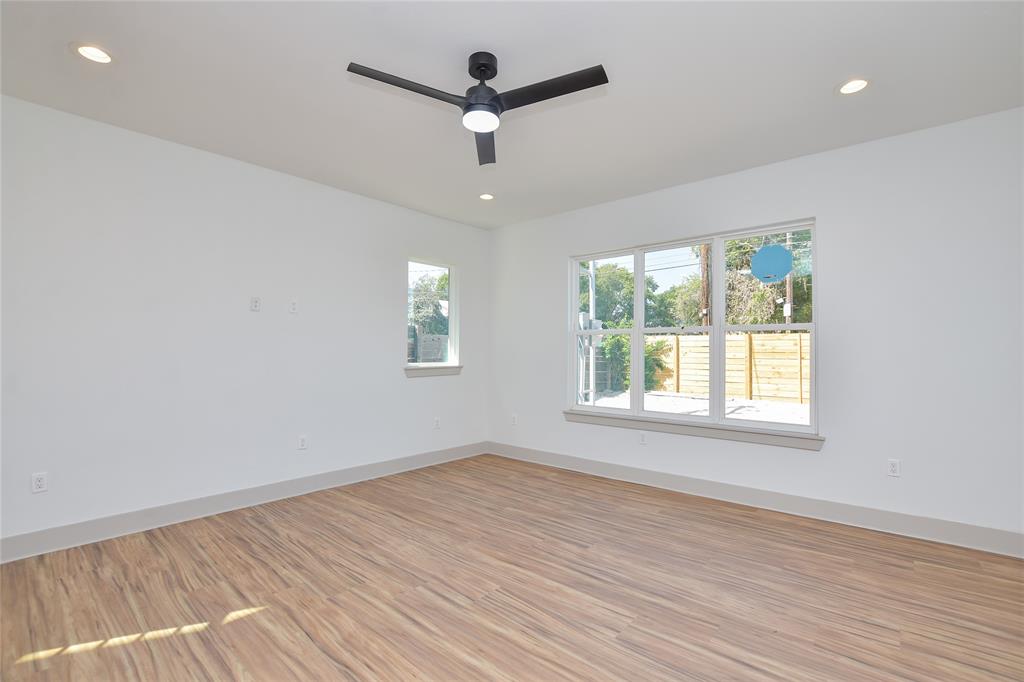 7103 Bennett Avenue, Unit 1 Austin, TX 78752 - Photo 5 of 25 an empty room with wooden floor ceiling fan and windows