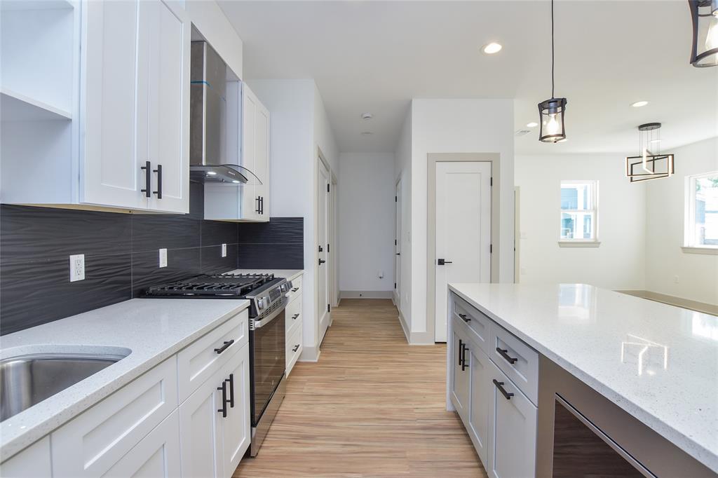 7103 Bennett Avenue, Unit 1 Austin, TX 78752 - Photo 9 of 25 a kitchen with granite countertop a sink and a stove top oven