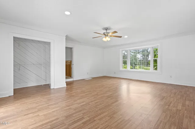 an empty room with wooden floor and window