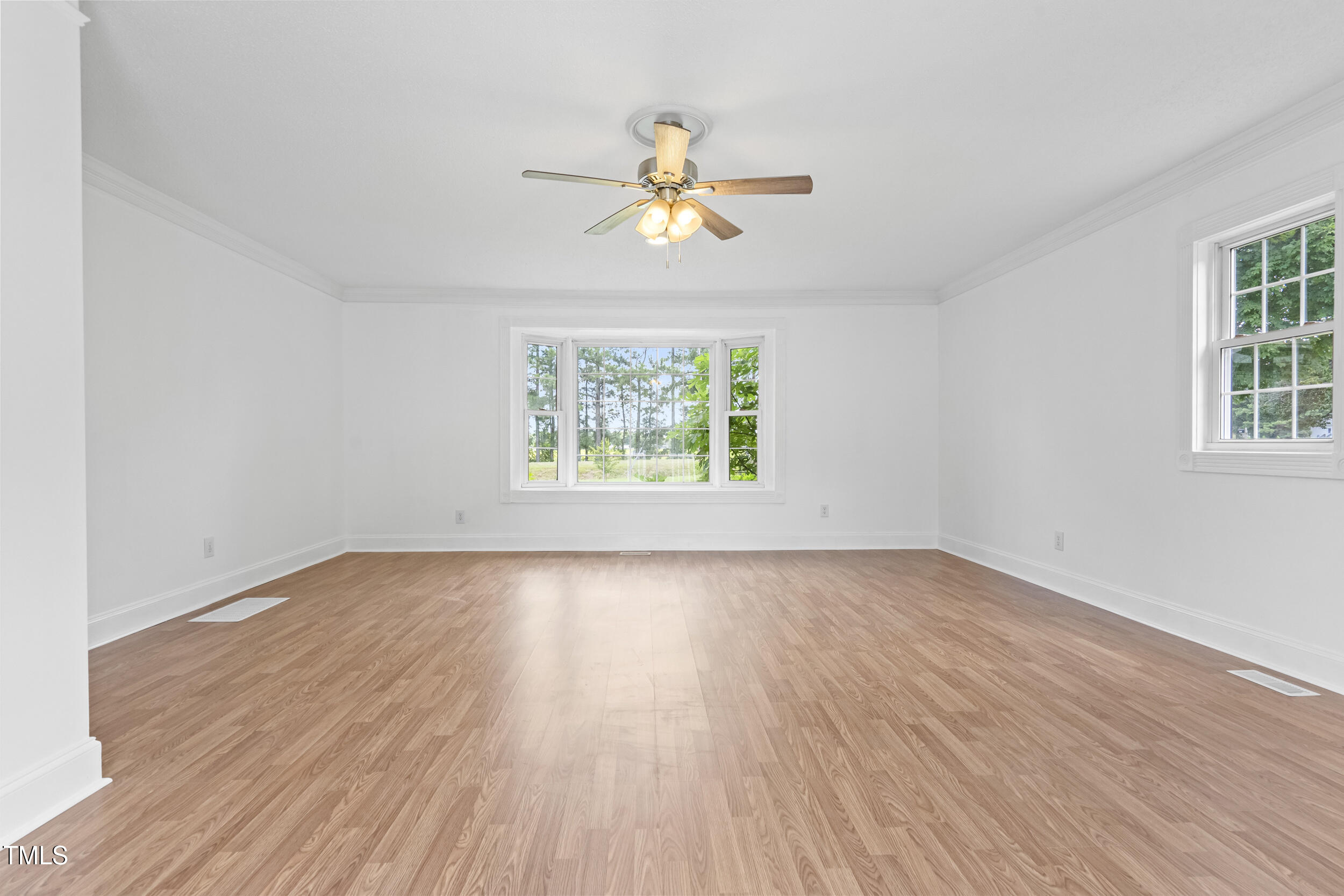 771 Brown Road Lillington, NC 27546 - Photo 31 of 37 an empty room with wooden floor chandelier fan and windows
