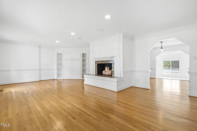 a view of a livingroom with wooden floor and a fireplace