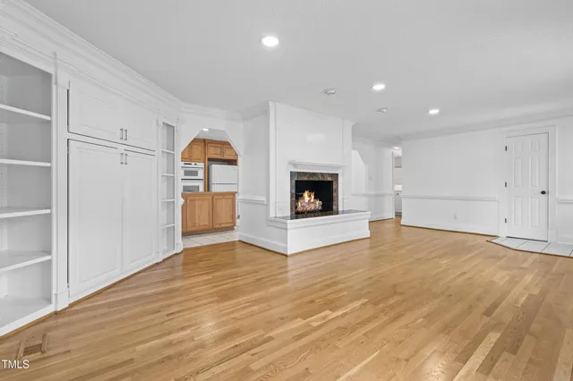 a view of empty room with wooden floor fireplace and windows