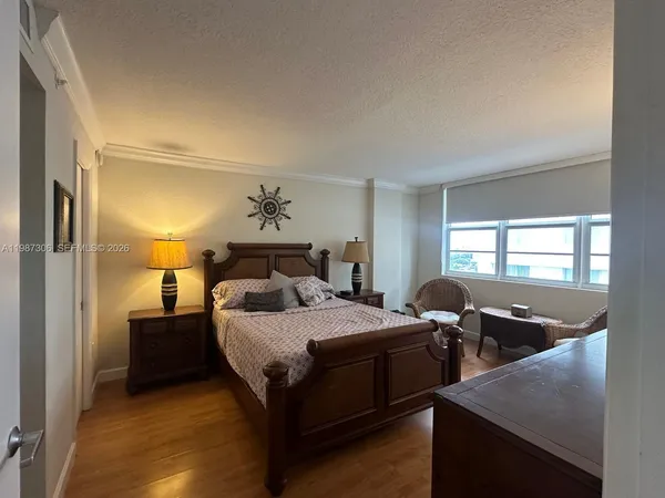 a bathroom with a granite countertop sink a mirror a shower and a toilet