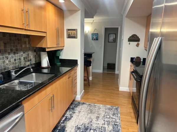 a kitchen with granite countertop a refrigerator and a sink