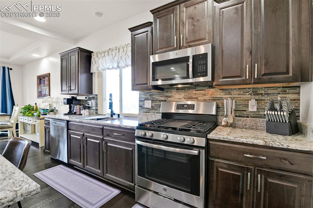 9290 Streamside Trail Fountain, CO 80817 - Photo 8 of 49 a kitchen with stainless steel appliances granite countertop a stove microwave and sink