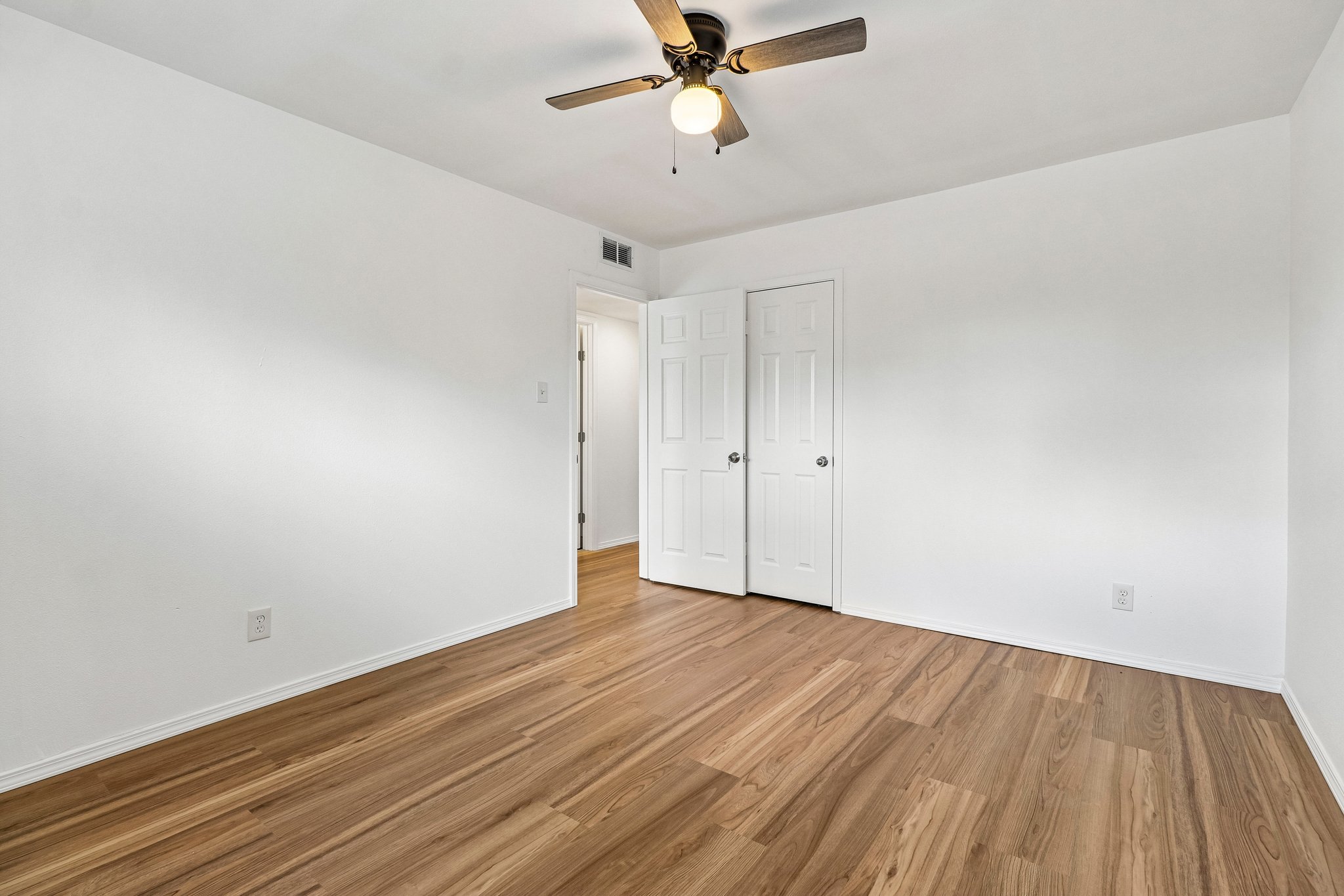 5809 Coventry Lane Austin, TX 78723 - Photo 16 of 35 A well-lit bedroom featuring durable wood flooring and ample storage.