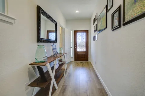 a view of a hallway with wooden floor and staircase