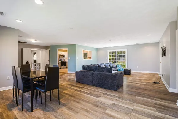a living room with furniture and a wooden floor
