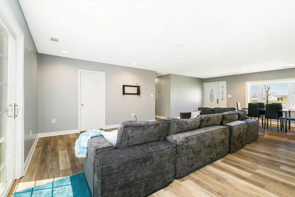 a living room with furniture and a wooden floor