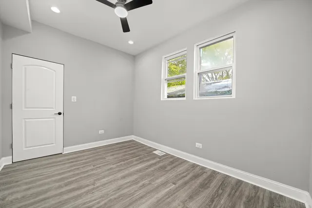 an empty room with wooden floor and window