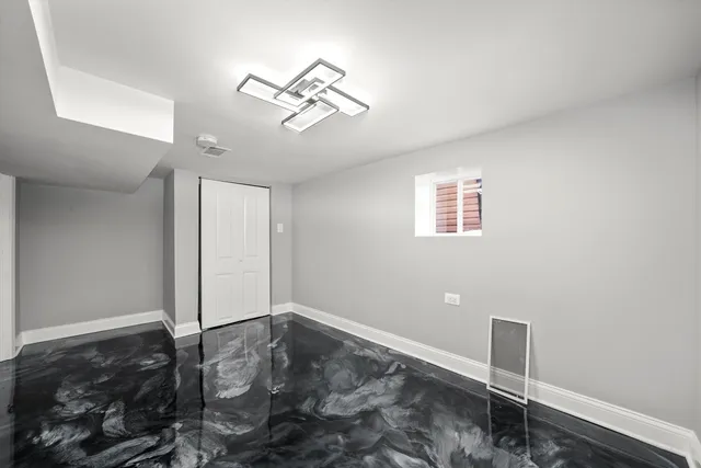 a view of a livingroom with a chandelier fan and wooden floor