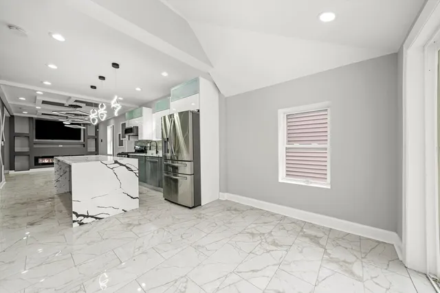 a view of a kitchen with refrigerator and chairs