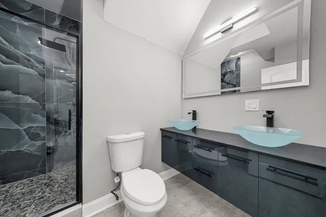 a bathroom with a sink a toilet and shower