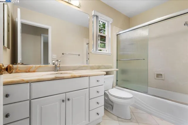 a bathroom with a granite countertop sink toilet and shower
