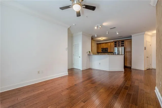 a view of a kitchen with a dishwasher a kitchen island hardwood floor and a sink