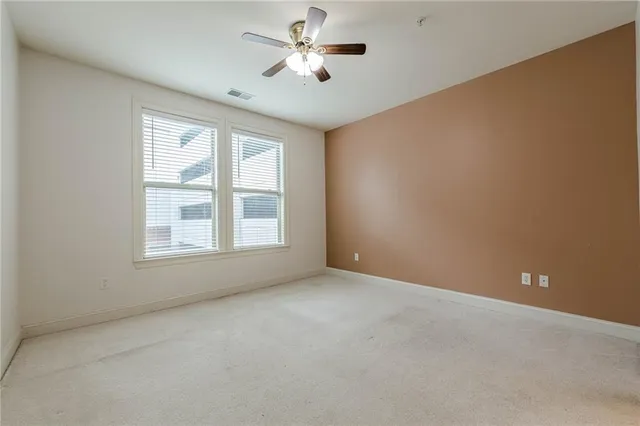 a view of a room with windows and chandelier fan