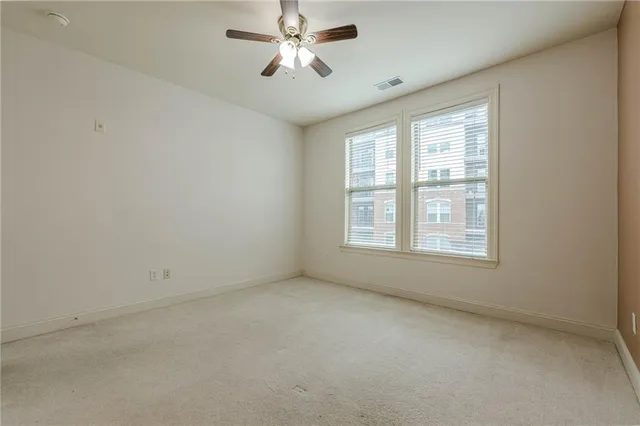 an empty room with a window and a fan