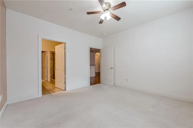 a view of an empty room and chandelier fan