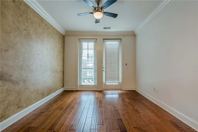 a view of wooden floor and a chandelier fan in a room