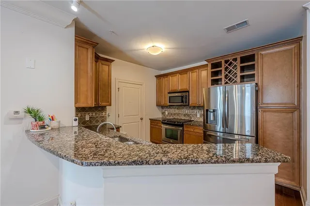 a kitchen with stainless steel appliances granite countertop a sink refrigerator and microwave