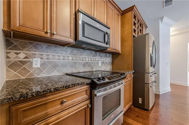 a kitchen with granite countertop stainless steel appliances and wooden cabinets