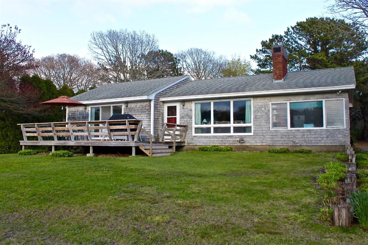 345 Monomoscoy Road Mashpee, MA 02649 - Photo 17 of 19 a backyard of a house with yard table and chairs