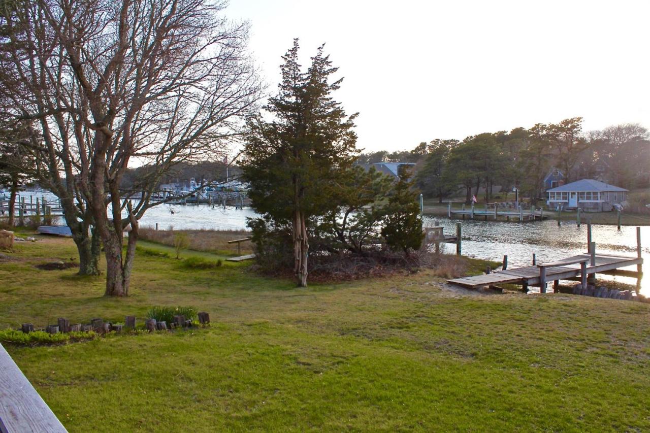 345 Monomoscoy Road Mashpee, MA 02649 - Photo 4 of 19 a view of a lake with a bench and trees