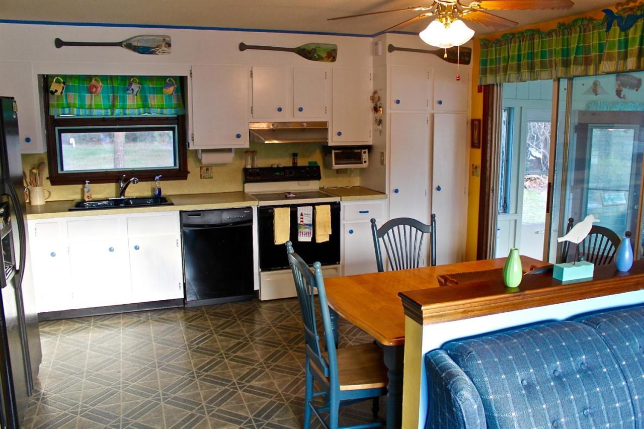 345 Monomoscoy Road Mashpee, MA 02649 - Photo 8 of 19 a kitchen with stainless steel appliances granite countertop a stove a refrigerator a dining table and chairs with wooden floor