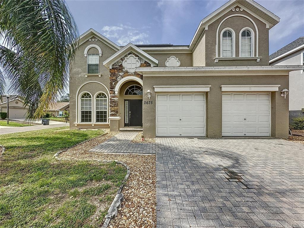 2675 Sand Hill Point Circle Davenport, FL 33837 - Photo 1 of 1 a front view of a house with a garden