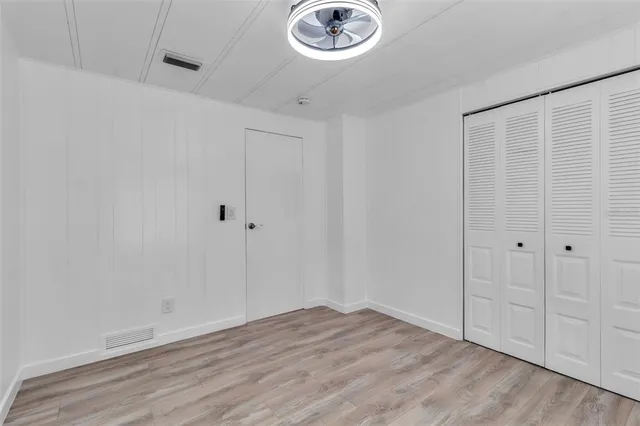 a view of empty room with wooden floor