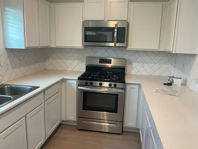 a kitchen with granite countertop a stove and a sink
