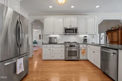 a kitchen with granite countertop a stove top oven sink and cabinets