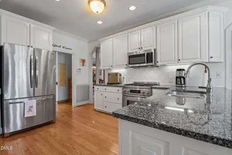 a large kitchen with stainless steel appliances granite countertop a stove a sink and a refrigerator