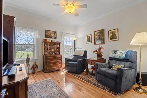 a front view of a dining room with furniture a chandelier and wooden floor